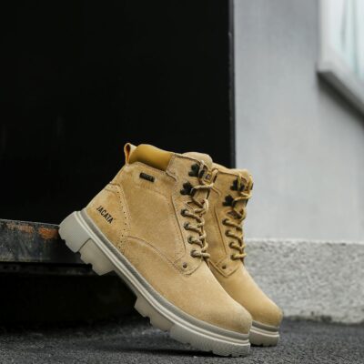 High-quality brown leather boots pictured outdoors on a textured surface. Ideal for fashion and lifestyle themes.