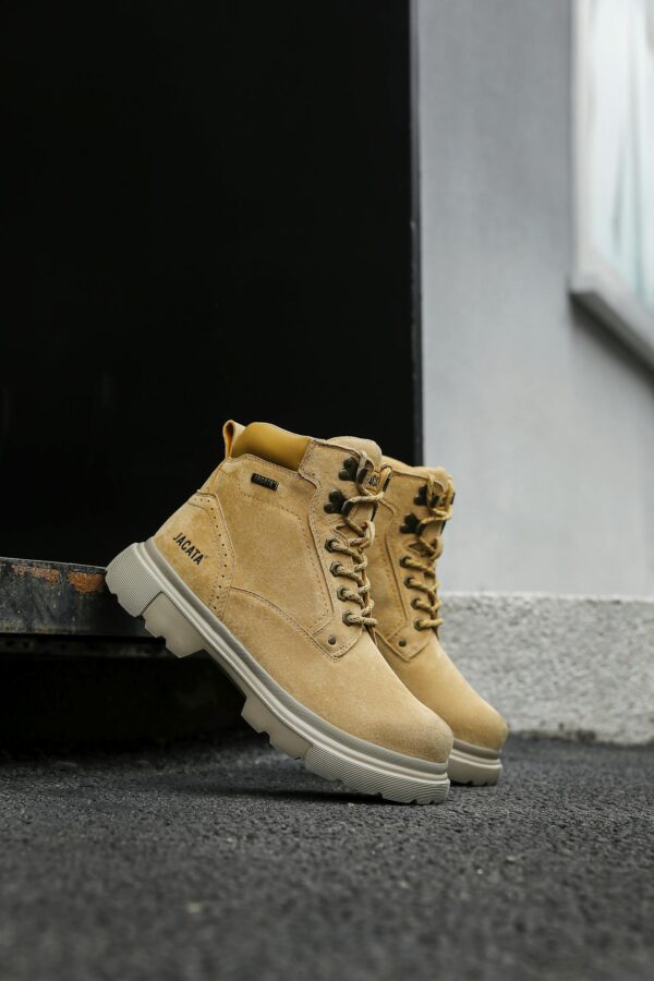 High-quality brown leather boots pictured outdoors on a textured surface. Ideal for fashion and lifestyle themes.