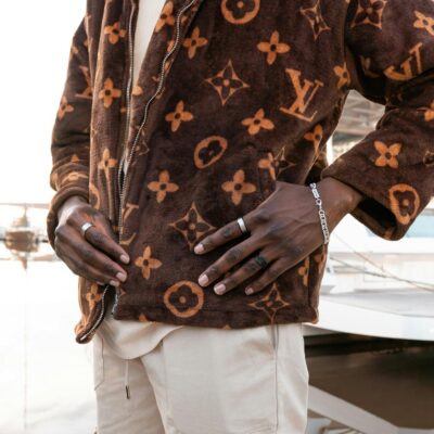 Stylish man in a designer jacket posing outdoors, showcasing luxury fashion.