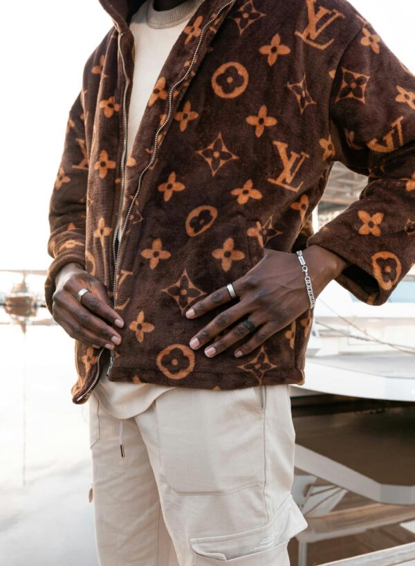Stylish man in a designer jacket posing outdoors, showcasing luxury fashion.
